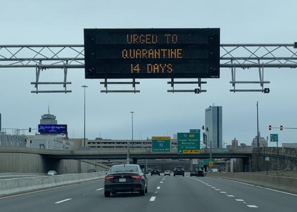 A LED billboard reading 'URGED TO QUARANTINE 14 DAYS'